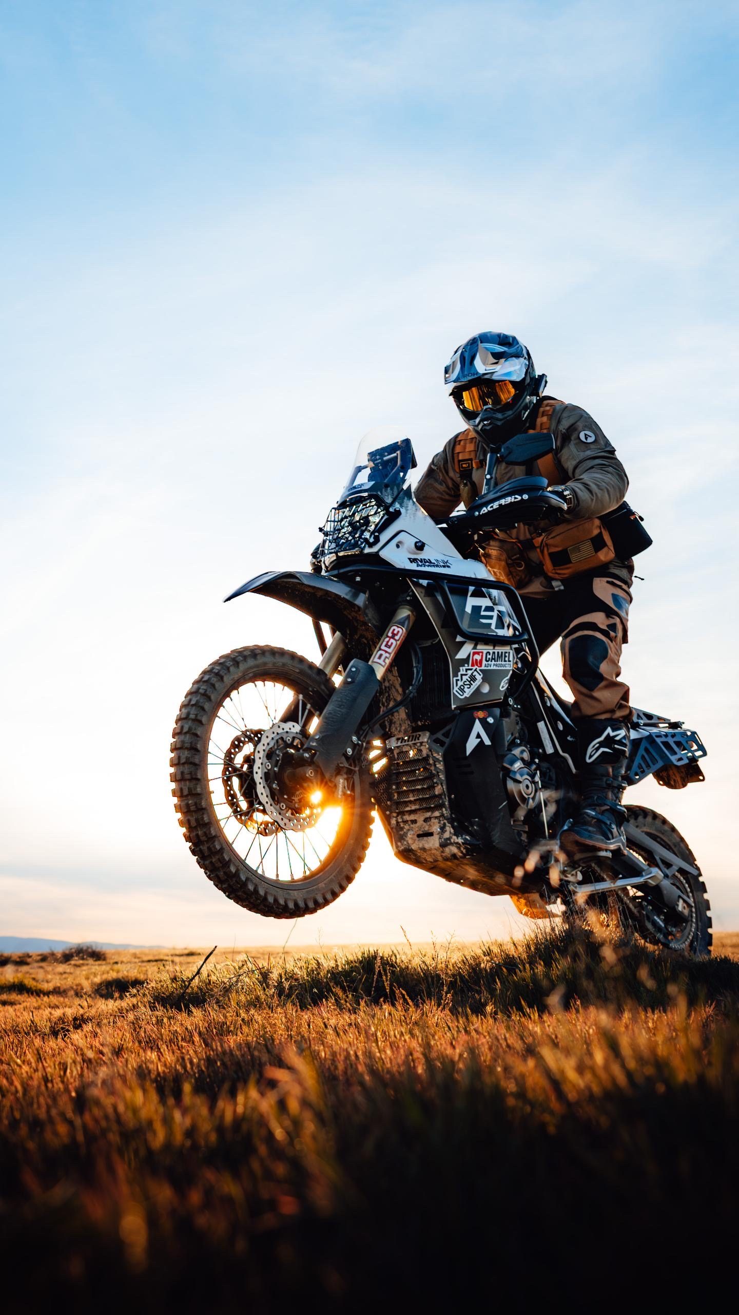Baja-ready Ténéré 700 in a golden-hour wheelie, sun-flare through the front wheel