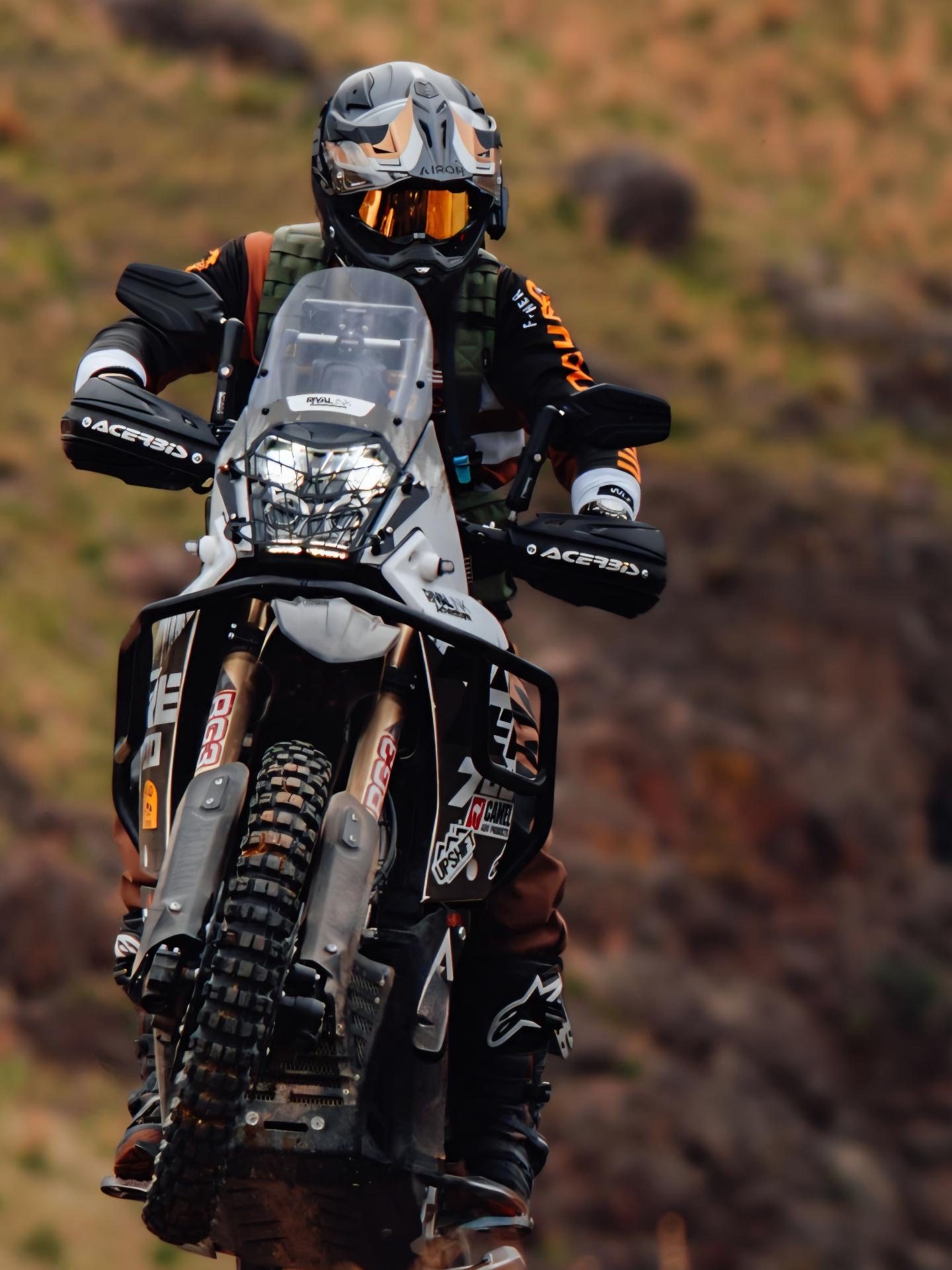 Front-on shot of the Ténéré, rider's hands on the grips, blurred terrain background